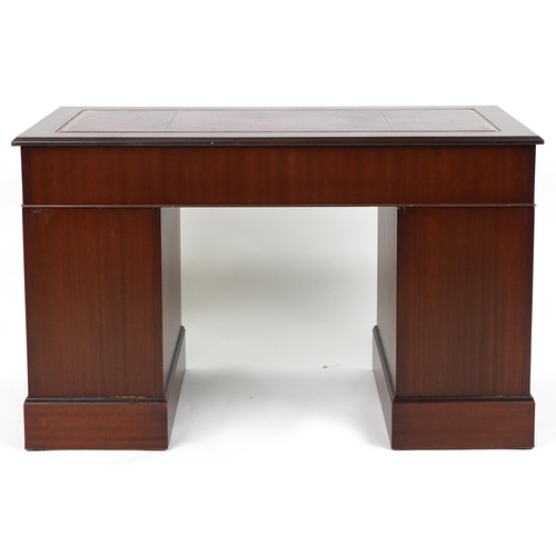 1111 - Mahogany twin pedestal desk with red tooled leather insert fitted with an arrangement of nine drawer... 