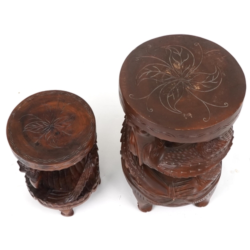 1055 - Two Chinese carved hardwood dragon design occasional tables, the largest 62cm high x 39cm in diamete... 