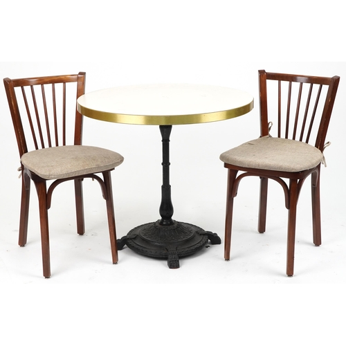 1165 - Contemporary circular bistro table with cast iron base and two mahogany chairs with cushions, the ta... 