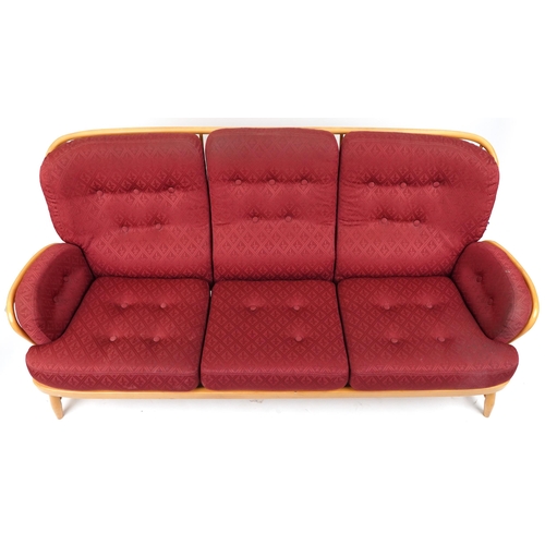 1069 - Ercol light elm Jubilee stick back three seater settee with red fleur de lis upholstered cushioned s... 