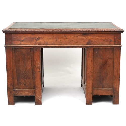 1015 - Victorian oak twin pedestal desk carved with a green man masks, fitted with an arrangement of nine d... 