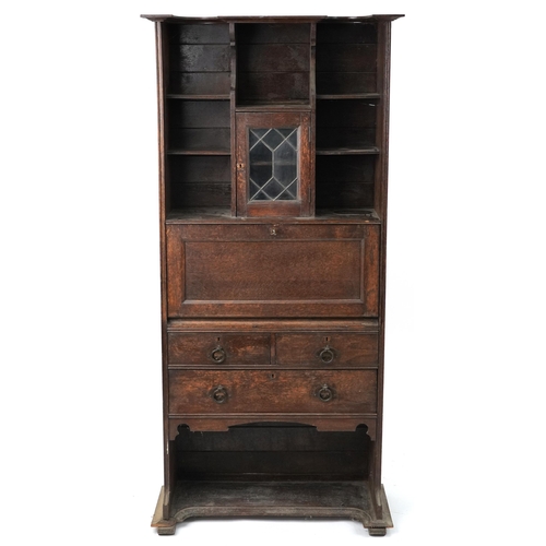 1105 - Arts & Crafts oak student's bureau fitted with leaded glass door above a fall and arrangement of thr... 