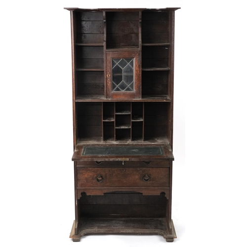 1105 - Arts & Crafts oak student's bureau fitted with leaded glass door above a fall and arrangement of thr... 