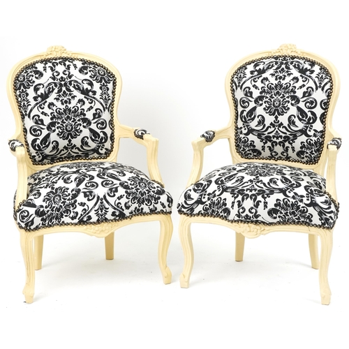 1106 - Pair of French style cream painted elbow chairs, each having cream and black floral upholstery, each... 