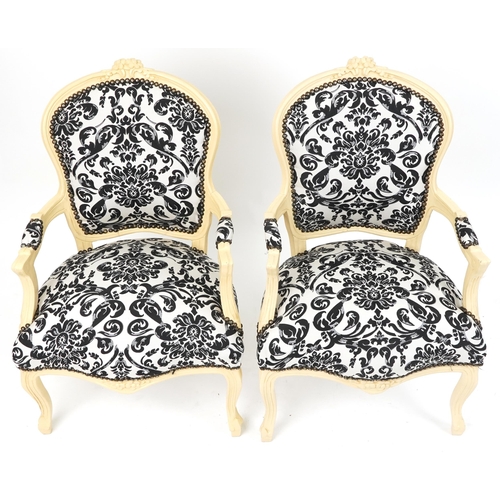 1106 - Pair of French style cream painted elbow chairs, each having cream and black floral upholstery, each... 