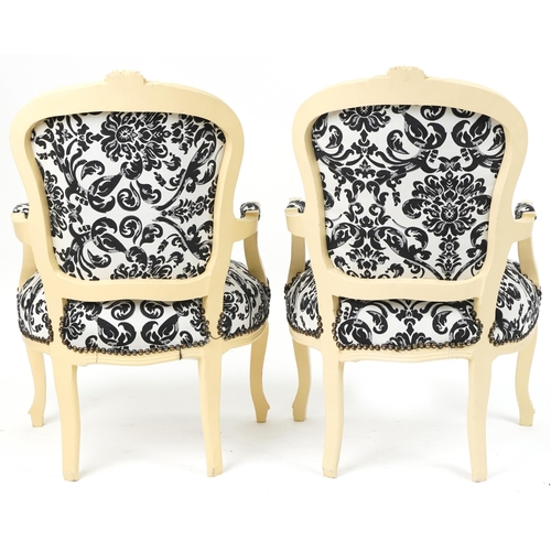 1106 - Pair of French style cream painted elbow chairs, each having cream and black floral upholstery, each... 