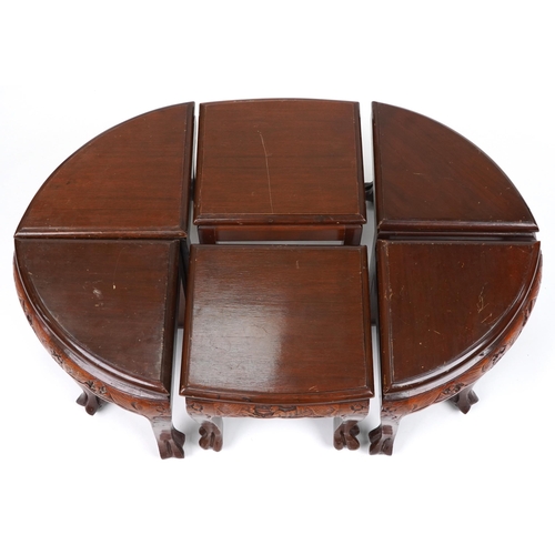 1143 - Nest of seven Chinese camphor wood occasional tables comprising an oval coffee table housing six occ... 