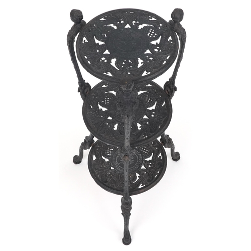 1205 - Victorian style cast iron three tier plant stand with figural mounts, 74cm high