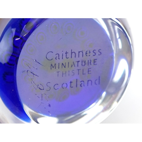 1499 - Two millefiori glass paperweights including a Caithness miniature thistle example, the largest 8cm i... 