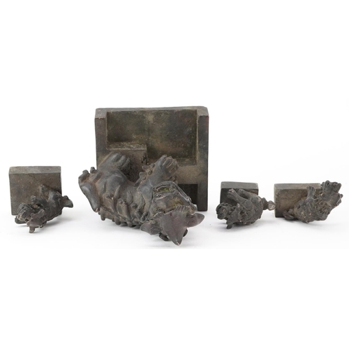 626 - Set of four Chinese patinated bronze interlocking desk seals in the form of qilins, 12cm high