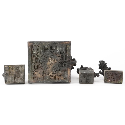 626 - Set of four Chinese patinated bronze interlocking desk seals in the form of qilins, 12cm high