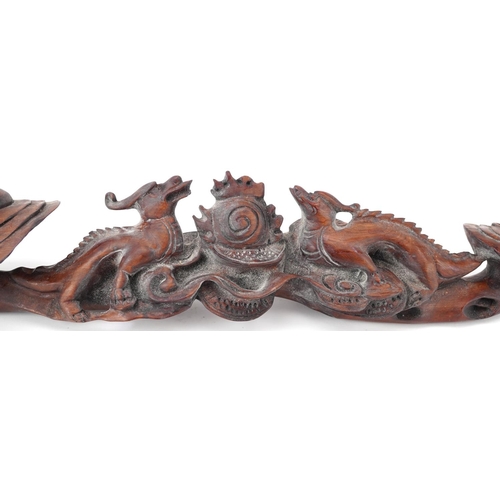 564 - Chinese hardwood ruyi sceptre carved with two dragons chasing the flaming pearl, 43cm wide