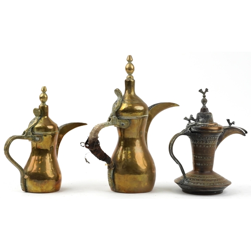 293 - Three Omani brass dallah coffee pots including an example with bird knops, the two others with impre... 