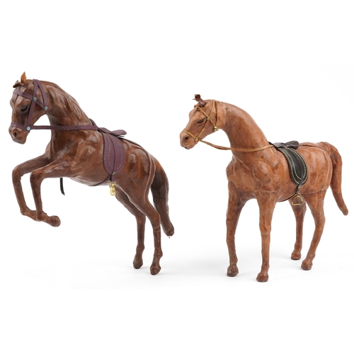 1549 - Manner of Liberty & Co, two leather covered horses including a rearing example, 40cm high