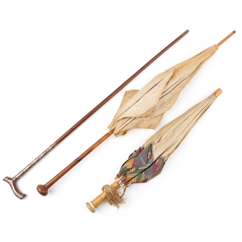 615 - Two early 20th century parasols and a Middle Eastern hardwood walking stick with foliate metal inlay... 