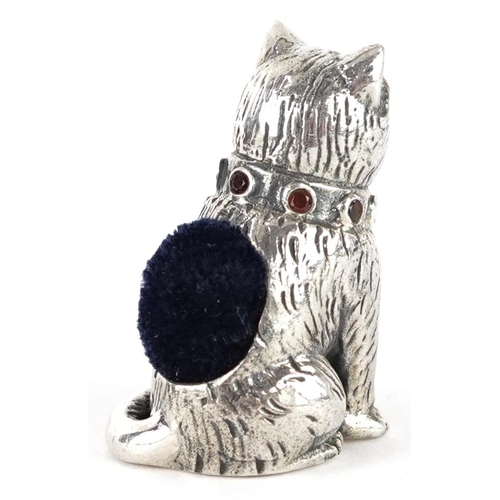 307 - Sterling silver pincushion in the form of a seated cat set with emerald eyes and garnet collar, 2.6c... 