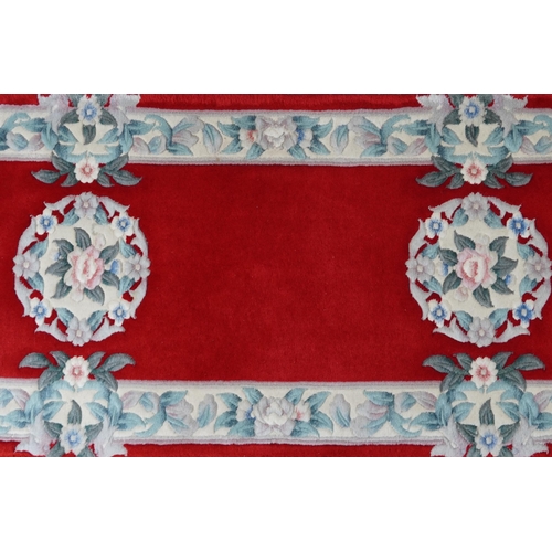 1223 - Three Chinese red ground floral rugs including a runner, the largest 255cm x 70cm