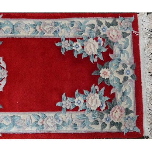 1223 - Three Chinese red ground floral rugs including a runner, the largest 255cm x 70cm