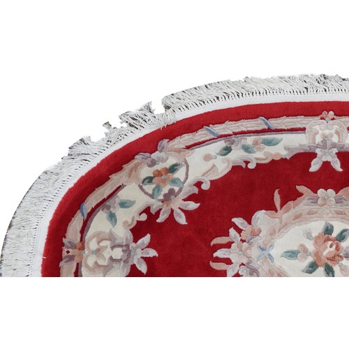 1226 - Four Chinese floral rugs comprising two circular and an oval example, the largest 167cm in diameter