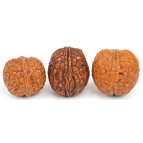 199 - Three Chinese walnuts carved with figures, the largest 4.5cm high