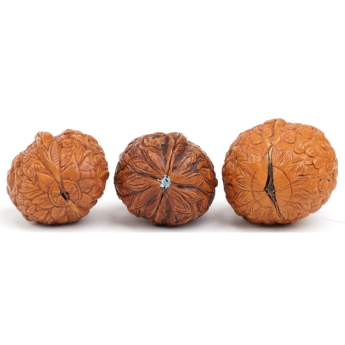 199 - Three Chinese walnuts carved with figures, the largest 4.5cm high