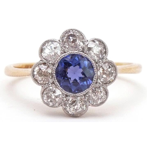 18ct gold diamond and sapphire flower head ring housed in a W Bruford & Son Ltd Eastbourne jeweller's box, the sapphire approximately 5.10mm in diameter x 2.86mm deep, total diamond weight approximately 0.55 carat, size J/K, 2.3g