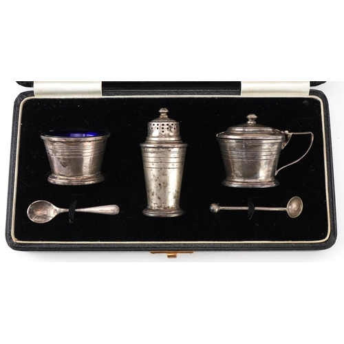 165 - Art Deco silver three piece cruet set with blue glass liners and two unassociated spoons housed in a... 