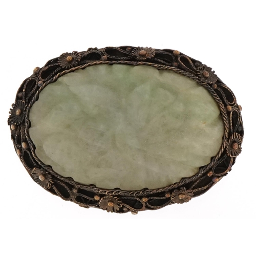 Chinese white metal filigree brooch inset with a green jade panel carved with foliage, 5cm wide, 22.0g
