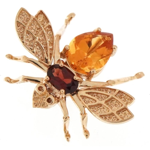 2055 - John C Rinker, 10K gold brooch in the form of a fly with garnet and citrine body, 2.6cm wide, 3.5g