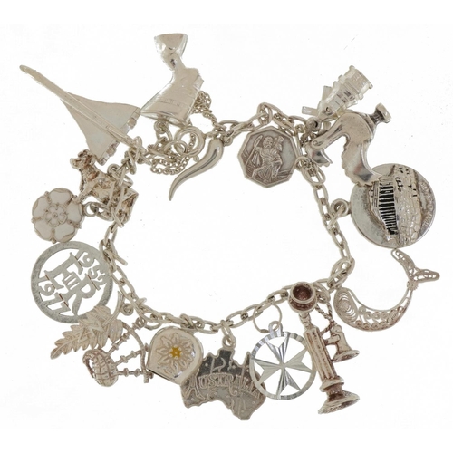 2377 - Silver charm bracelet with a collection of mostly silver charms including Concorde, Nefertiti, stick... 