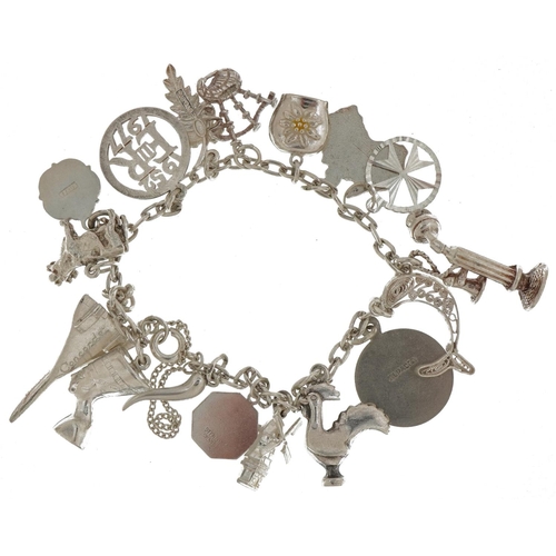 2377 - Silver charm bracelet with a collection of mostly silver charms including Concorde, Nefertiti, stick... 