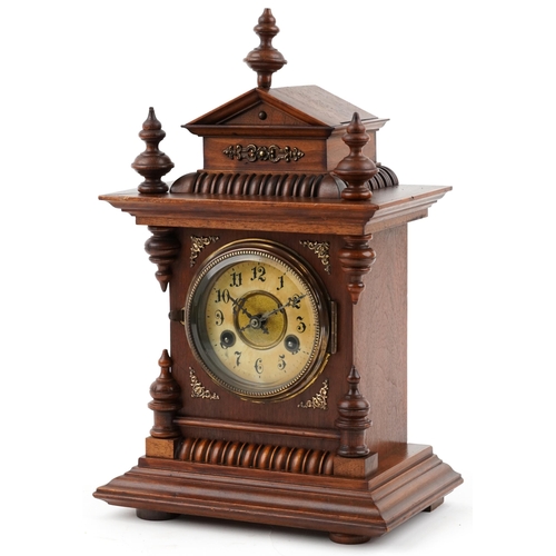 Junghans architectural walnut mantle clock striking on a gong having circular chapter ring with Arabic numerals, 42cm high