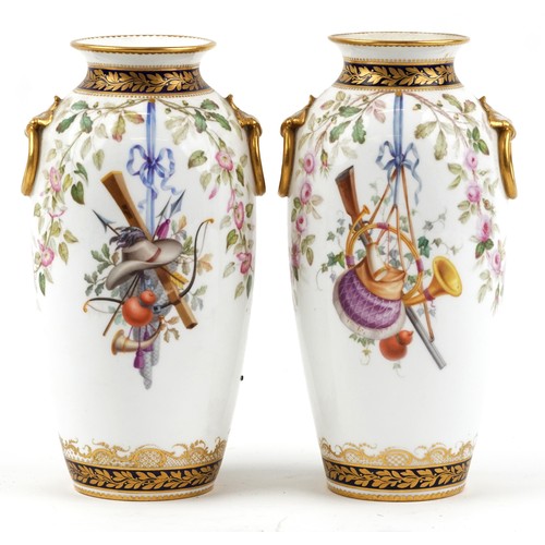 Pair of 19th century European porcelain vases with ring turned handles hand painted with hanging game amongst flowers, each 24cm high