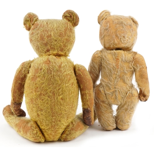 1520 - Two golden straw filled teddy bears with jointed limbs and beaded eyes, the largest with bells, the ... 