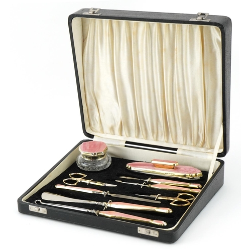 Davis Moss & Co, Art Deco silver gilt and pink guilloche enamel manicure/vanity set housed in a velvet and silk lined fitted case, Birmingham circa 1930, the largest 20.5cm in length