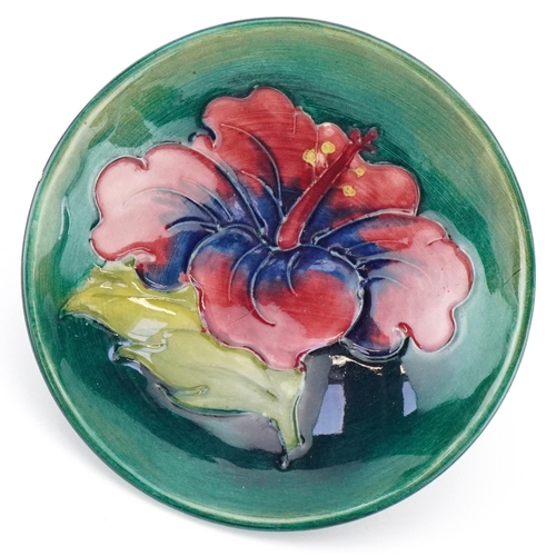 96 - Moorcroft pottery footed dish hand painted and tubelined in the Hibiscus pattern, paper label to the... 