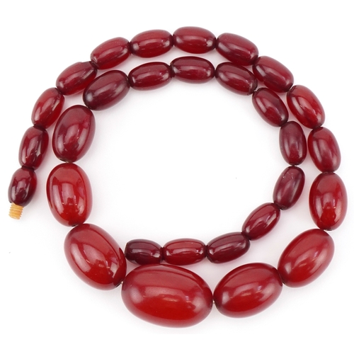 2304 - Cherry amber coloured graduated bead necklace, the largest bead approximately 25mm x 17mm in diamete... 