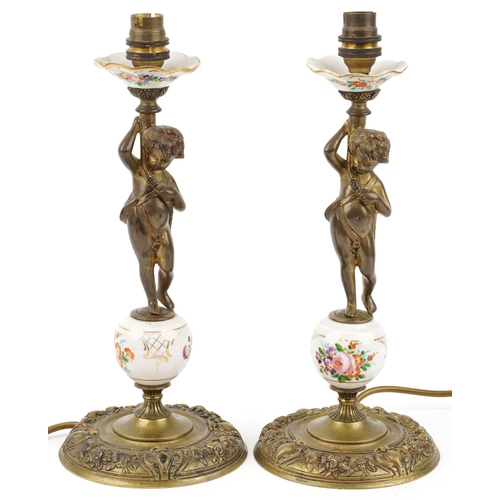 1374 - Pair of gilt brass and porcelain Putti design candlesticks hand painted with flowers, each 35cm high