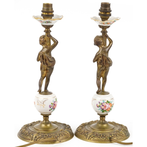 1374 - Pair of gilt brass and porcelain Putti design candlesticks hand painted with flowers, each 35cm high