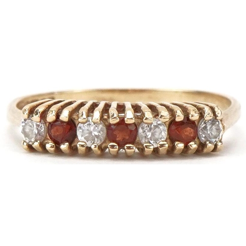 2210 - 9ct gold garnet and clear stone half eternity ring, size L/M, 1.3g