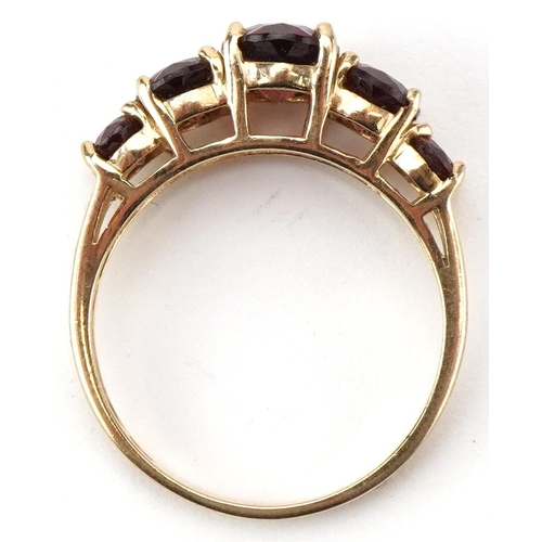 2206 - 9ct gold graduated garnet five stone ring, the largest garnet approximately 8.10mm x 6.10mm x 4.0mm ... 