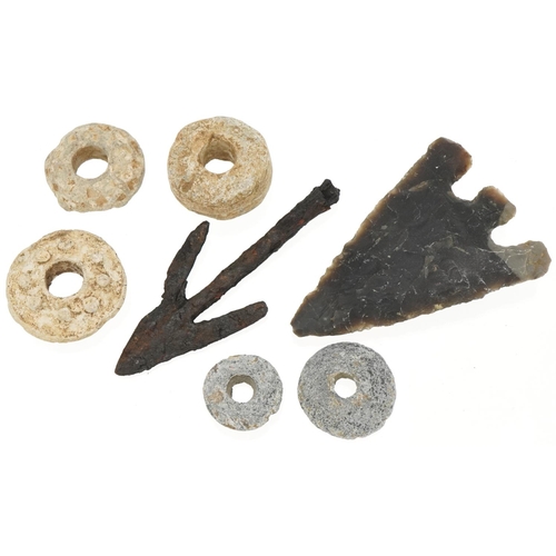 540 - Five lead spindle whorls and two arrow heads, possibly Roman and stone age, the largest 8cm in lengt... 