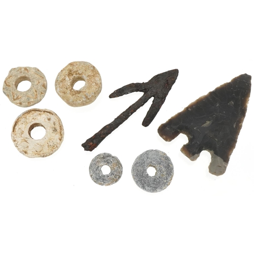 540 - Five lead spindle whorls and two arrow heads, possibly Roman and stone age, the largest 8cm in lengt... 