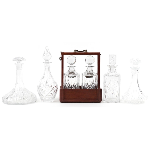 1188 - Six glass decanters including a pair housed in a hardwood tantalus with bronze mounts and silver pla... 