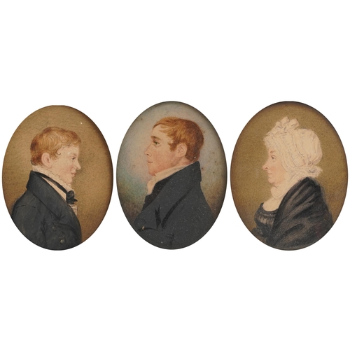 Three Georgian oval hand painted portrait miniatures housed in ebonised frames, including one of an elderly female wearing a white bonnet and two of young gentlemen, the largest 8.5cm x 7cm excluding the mount and frame
