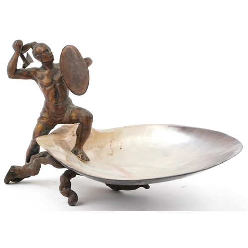 24 - 19th century gilt cast metal figure of a Mohawk warrior mounted on a mother of pearl dish, 20.5cm wi... 