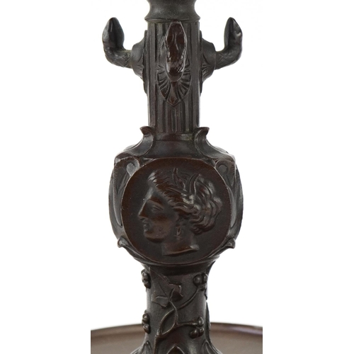 19 - Pair of Victorian Neo-Classical bronze candlesticks decorated with portraits and flowers, 23cm high