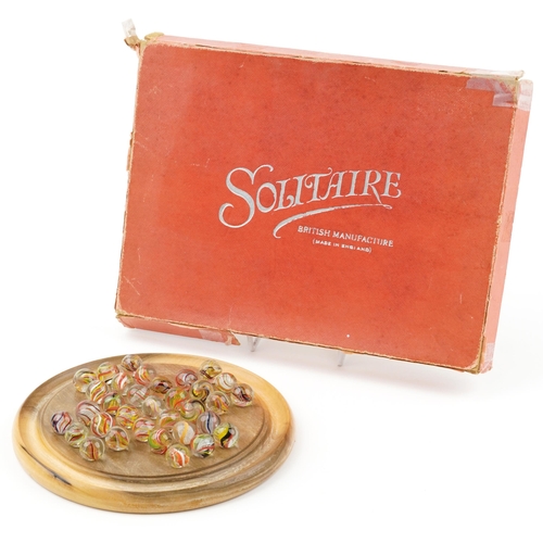 1504 - Boxed wooden solitaire board and selection of air twist marbles, the board 20cm in diameter