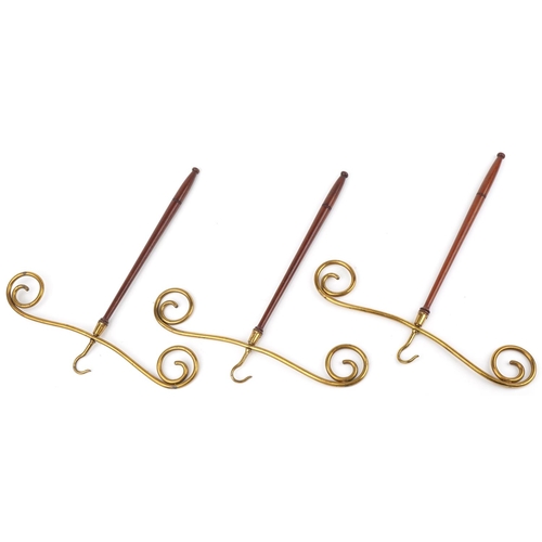 319 - Three Edwardian mahogany and brass gown hangers, each 50cm high