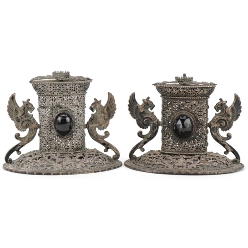 322 - Two of European white metal filigree ornaments with winged dragon handles set with black cabochons, ... 